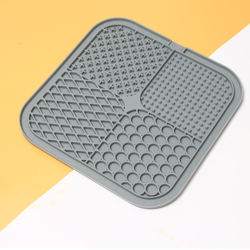 Grey silicone mat with textured surface on a yellow and white background