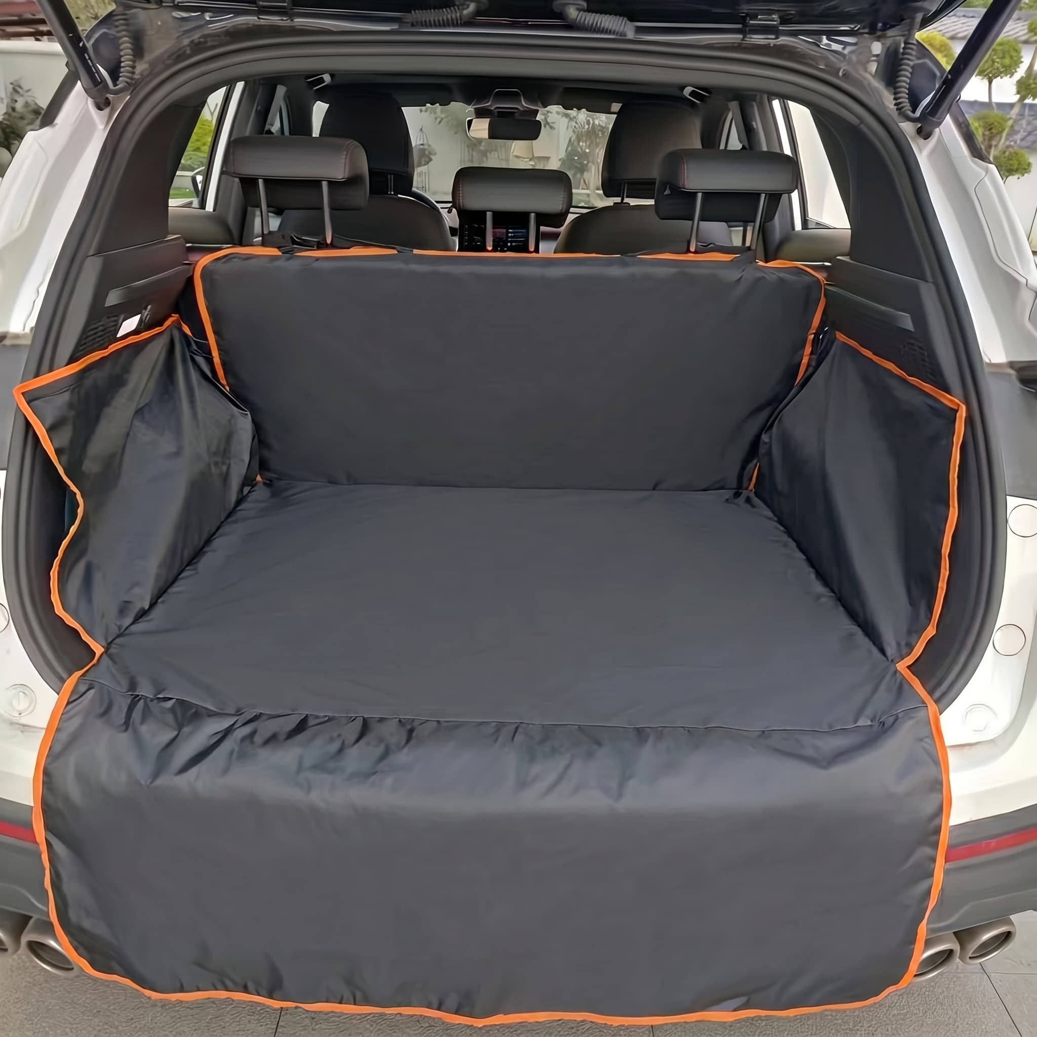 Car trunk with a black pet seat protector with orange trim