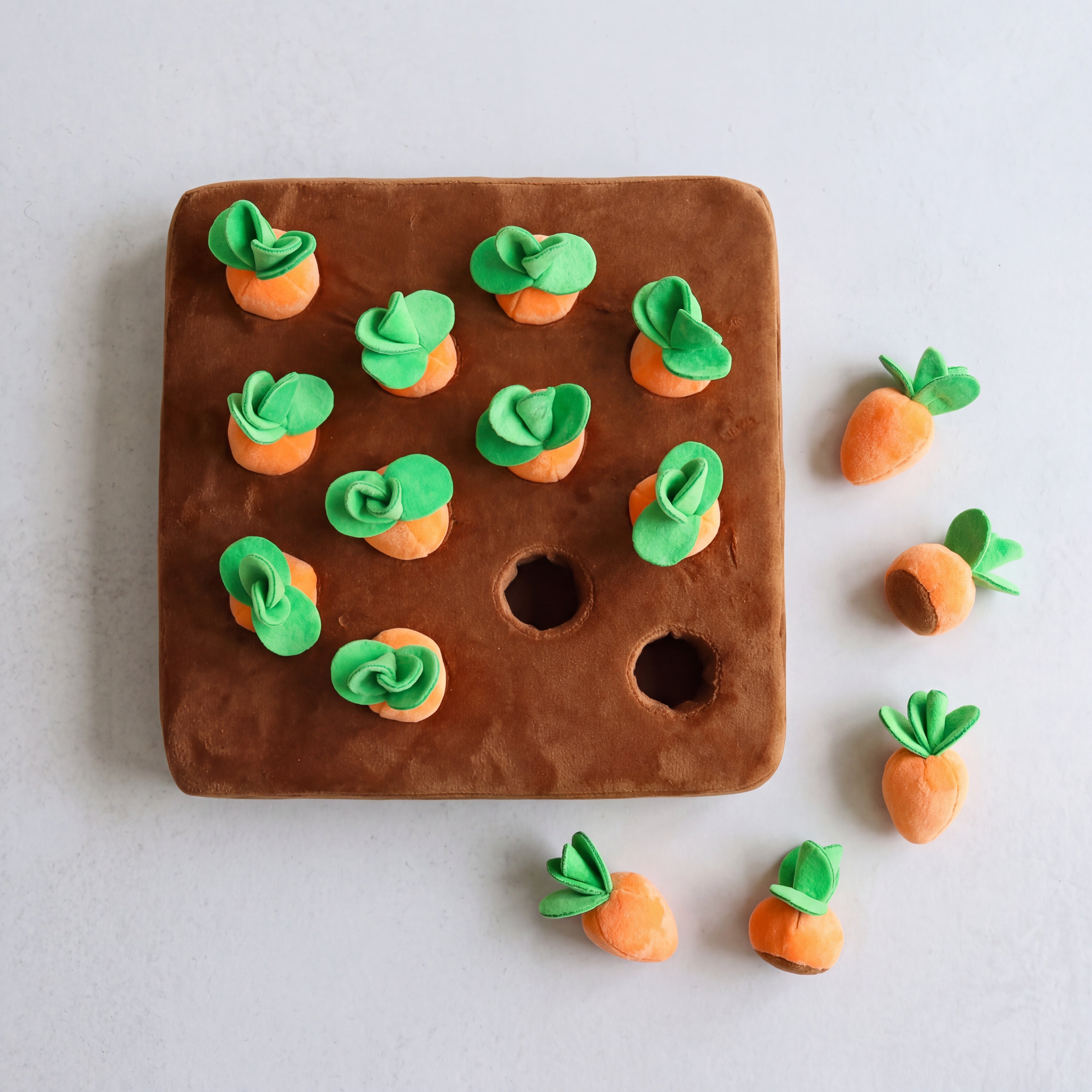 Decorative carrot-shaped cookies on a brown board with a plain background