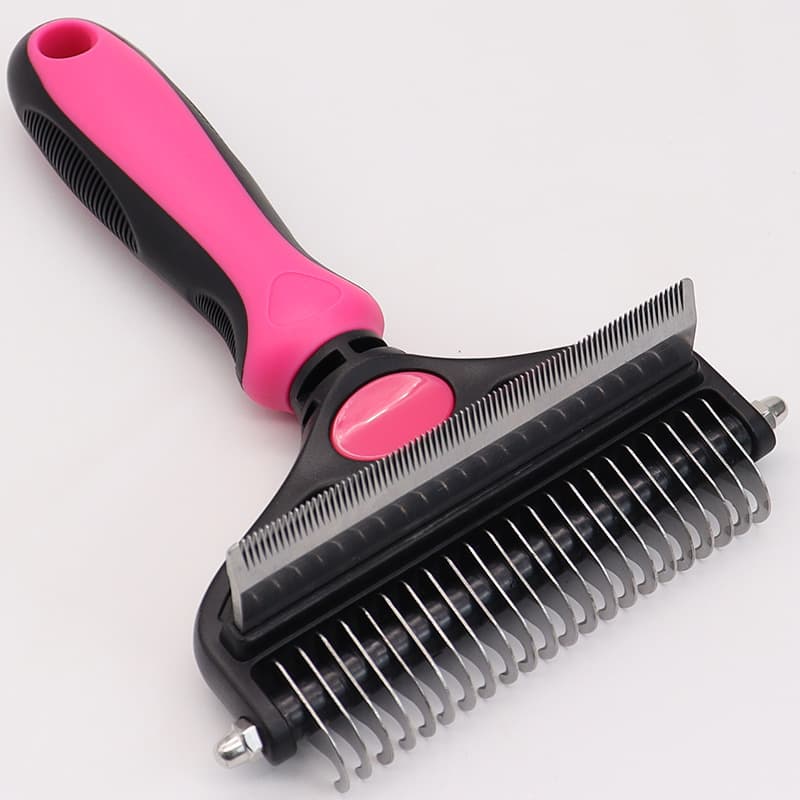 Pet grooming brush with pink handle on a white background