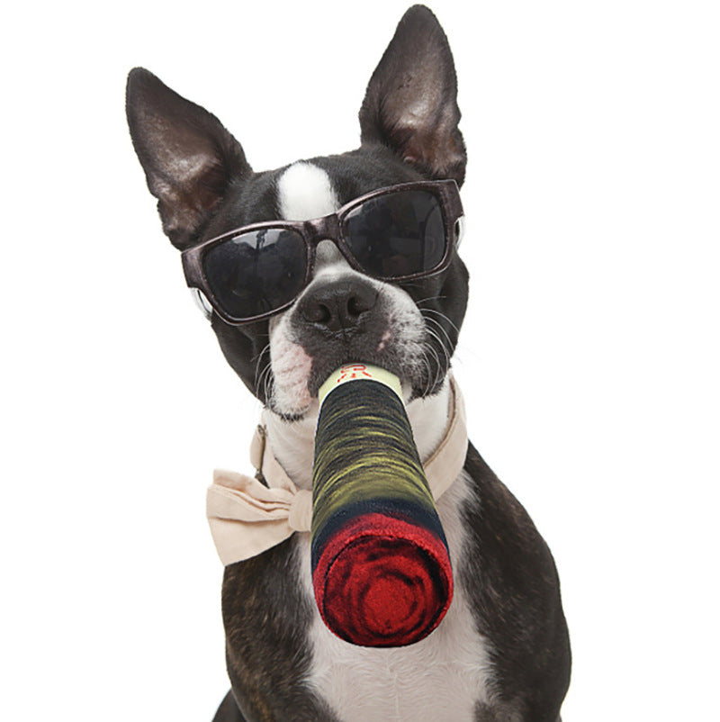 Dog wearing sunglasses holding a colorful rolled-up toy on a white background