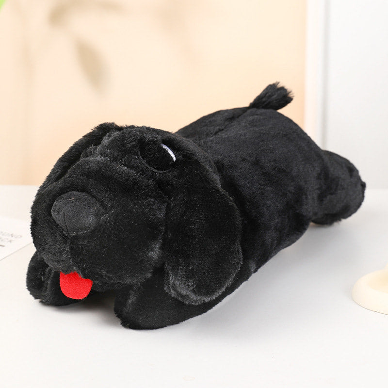 Black plush dog toy with a red tongue on a light background