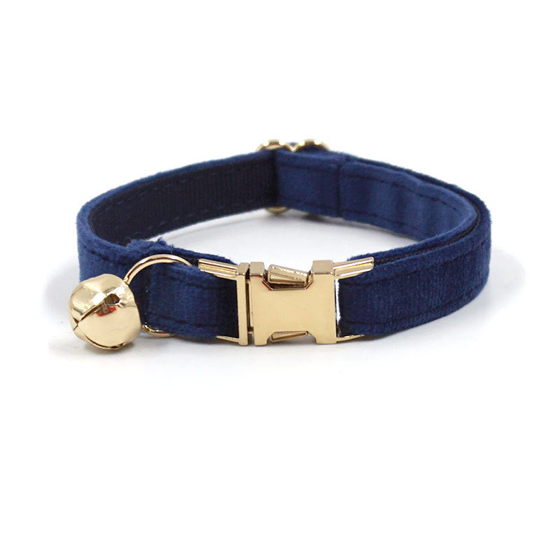 Navy blue cat collar with gold buckle and bell on a white background