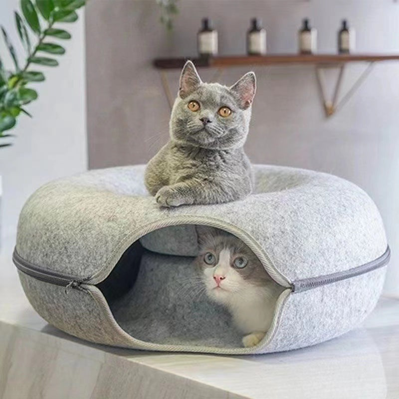 Two cats inside a cozy pet bed with a neutral background