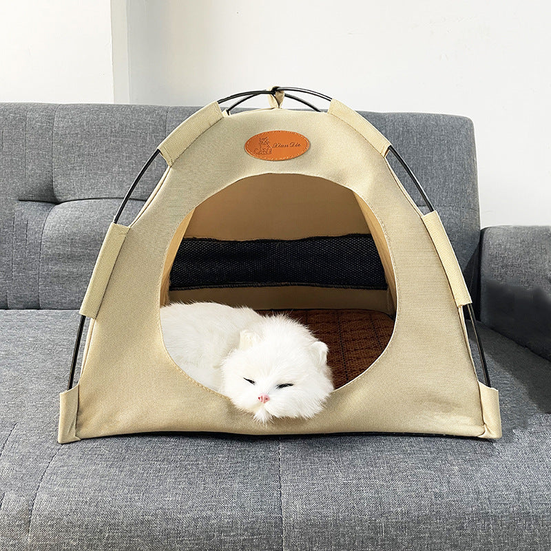 White cat inside a beige pet tent on a gray couch