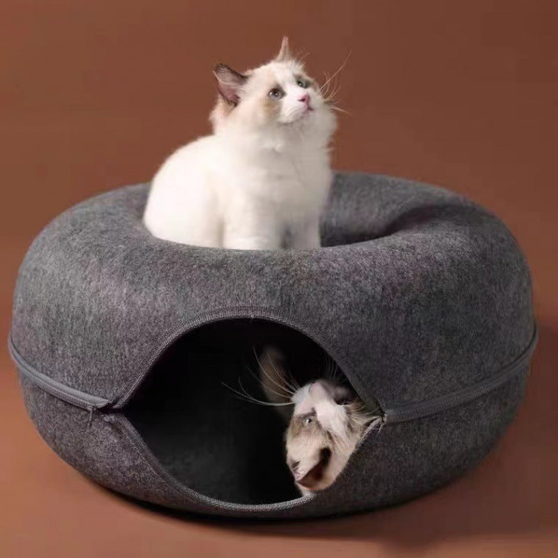 Two cats inside a grey pet bed on a brown background