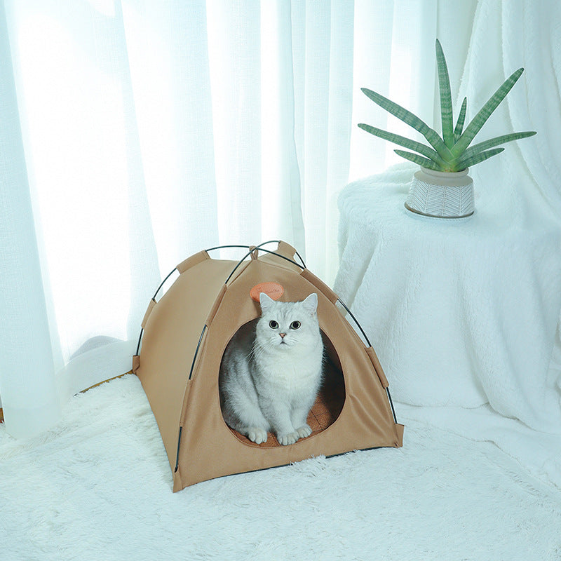 Cat inside a beige pet tent with a white curtain and plant in the background