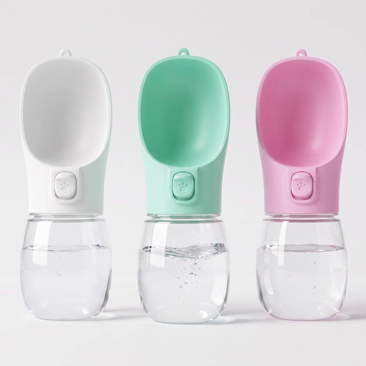 Three medium portable pet water bottles in white, mint green and pink displayed side by side on white background