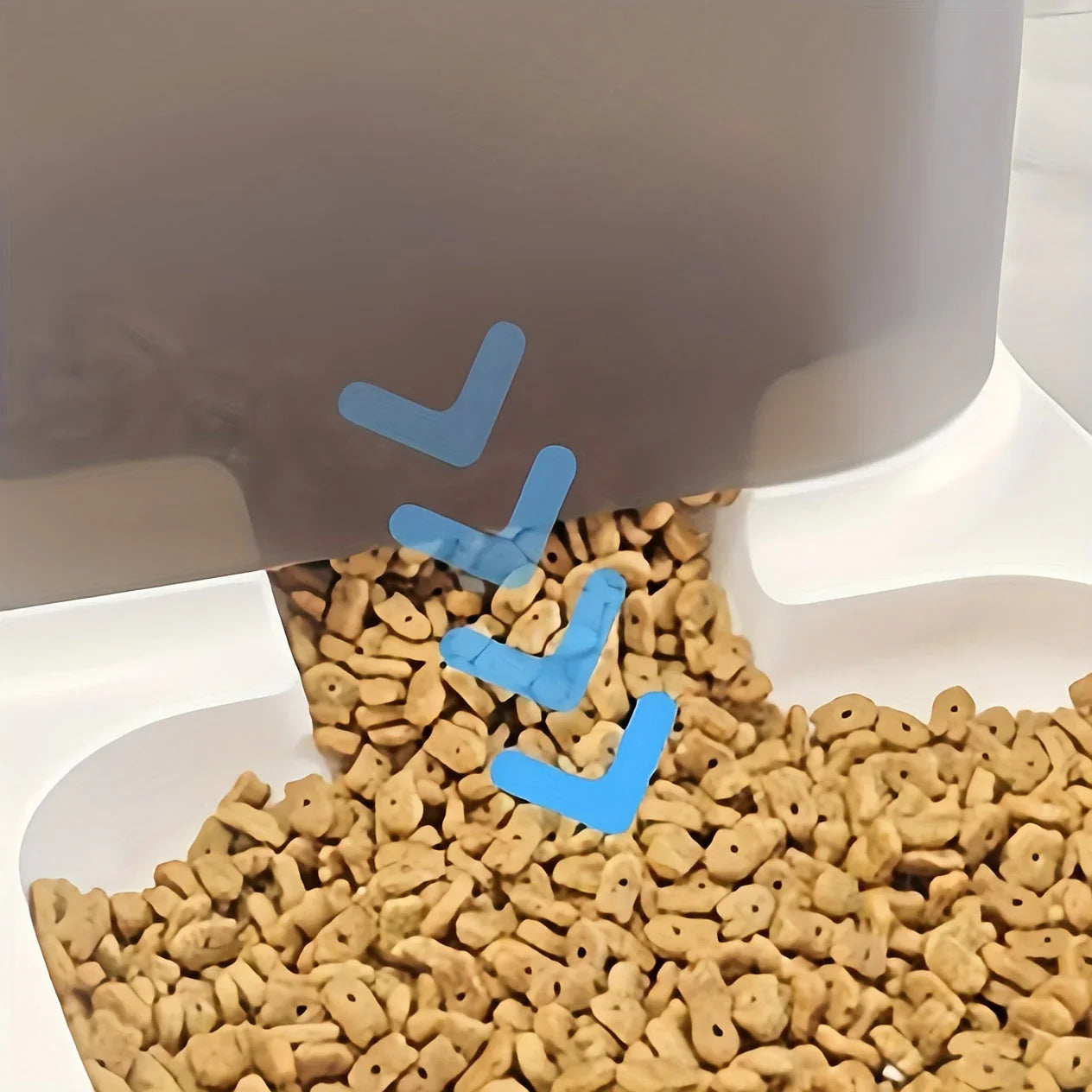 Dog food being dispensed from a bowl onto a white surface.