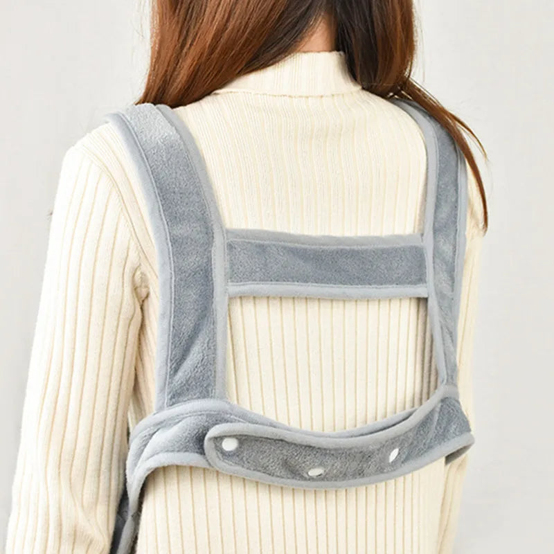 Person wearing a grey back brace against a plain background