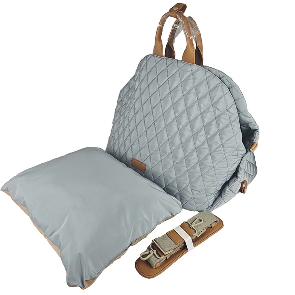 Quilted dog carrier with pillow and straps on a white background