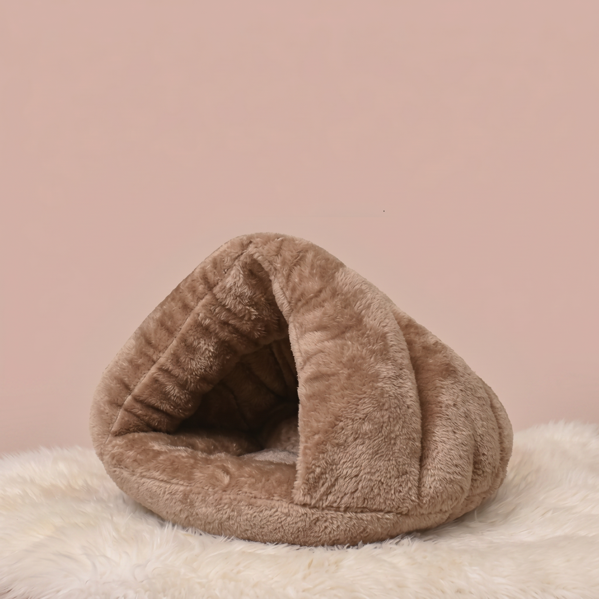 Brown plush pet bed on a pink background