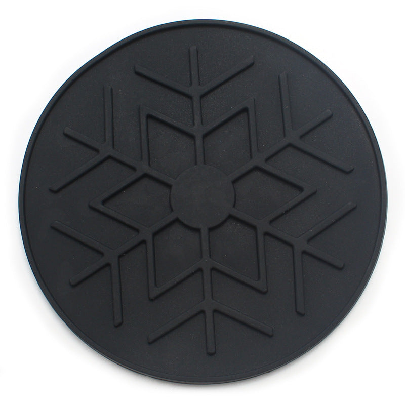 Black circular mat with a textured design on a white background
