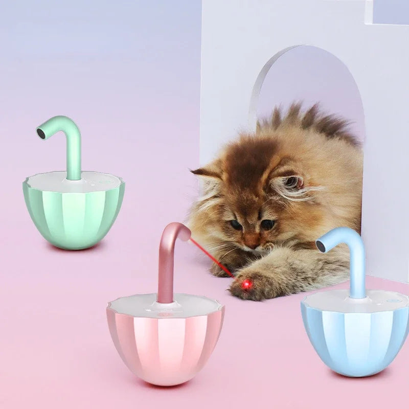 Cat interacting with a colorful pet toy on a pink background