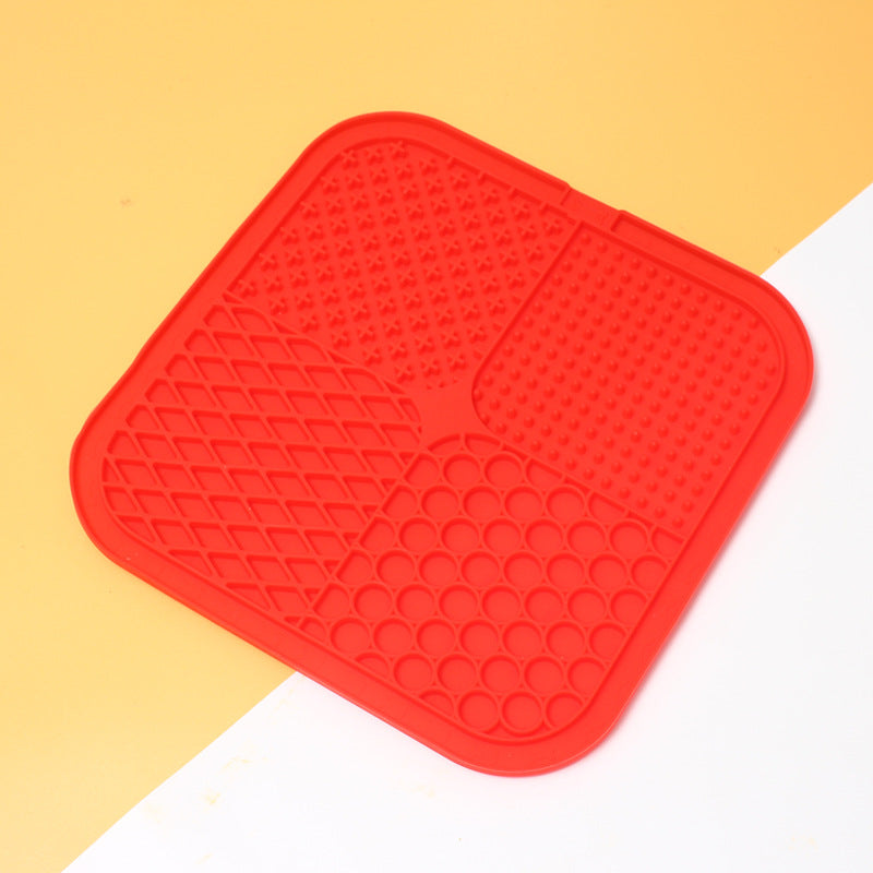 Red silicone mat with textured surface on a yellow and white background