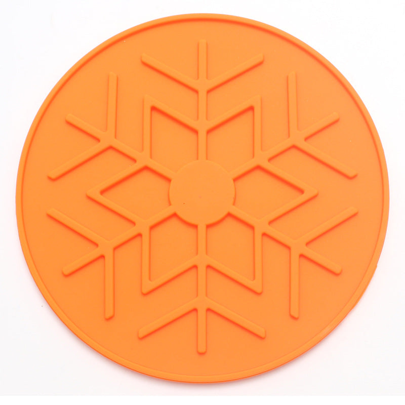 Orange silicone mat with snowflake pattern on a white background