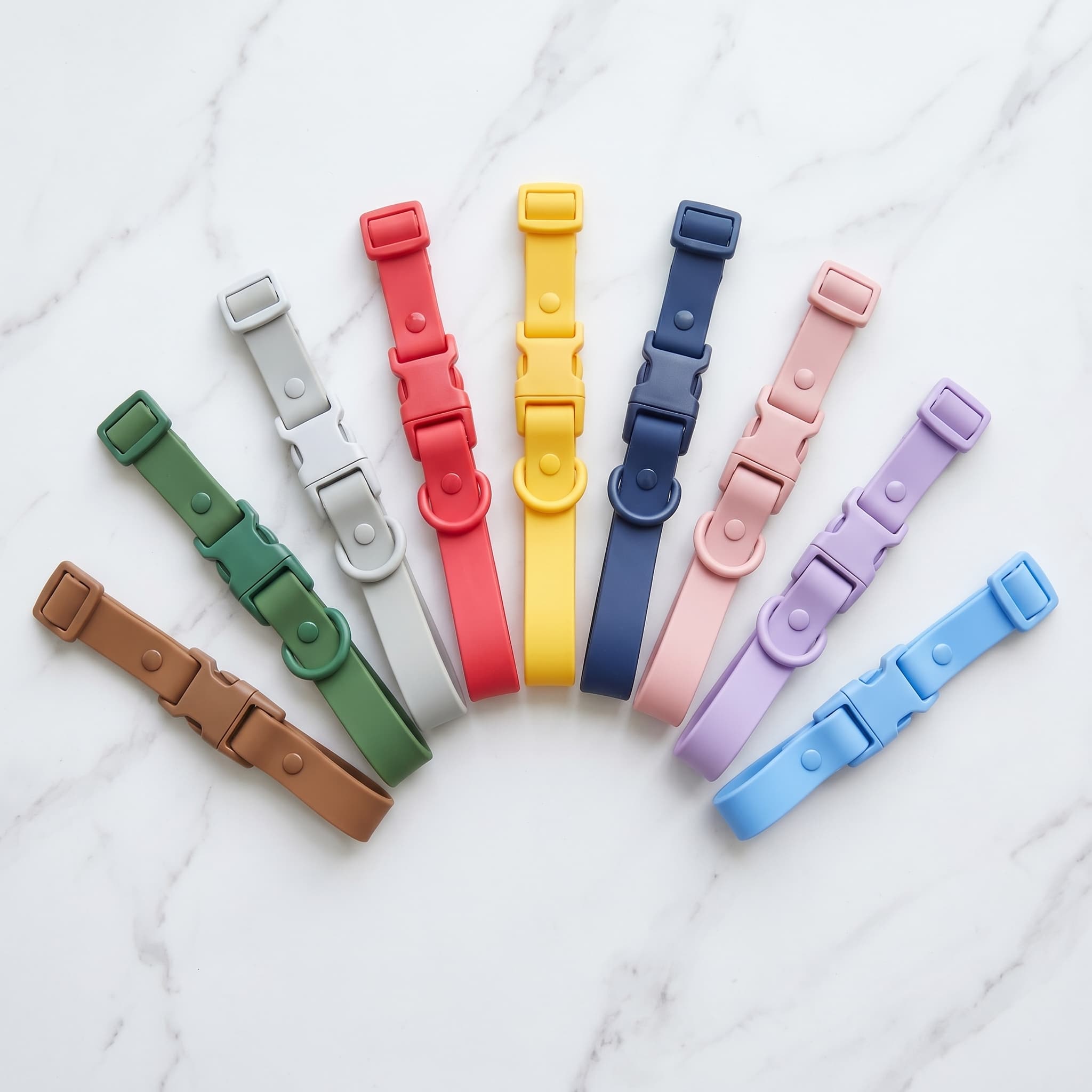 9 different coloured waterproof odor free dog collars in a row with a white background