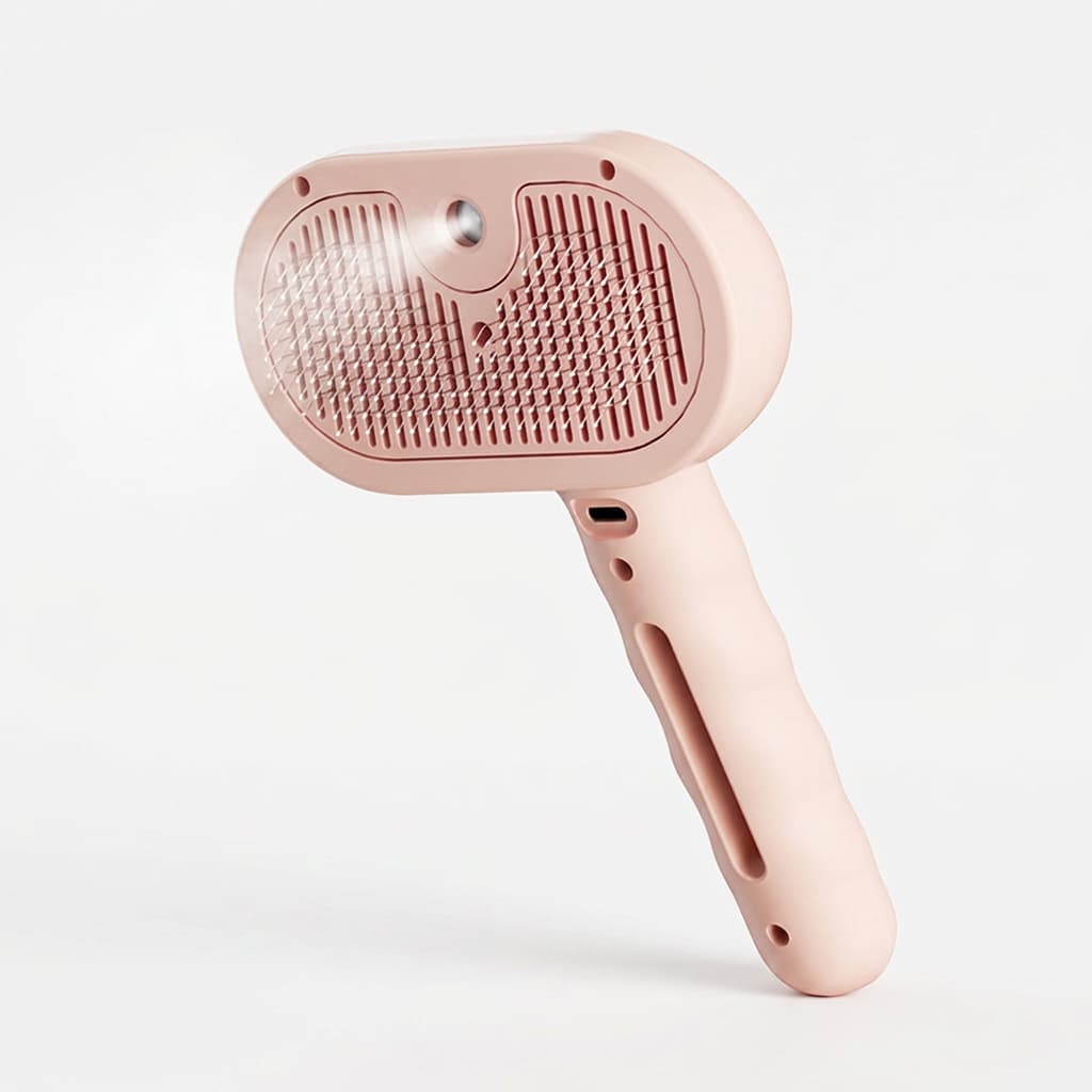 A pink pet grooming brush with a soft silicone handle and a textured bristle head, shown on a clean white background.