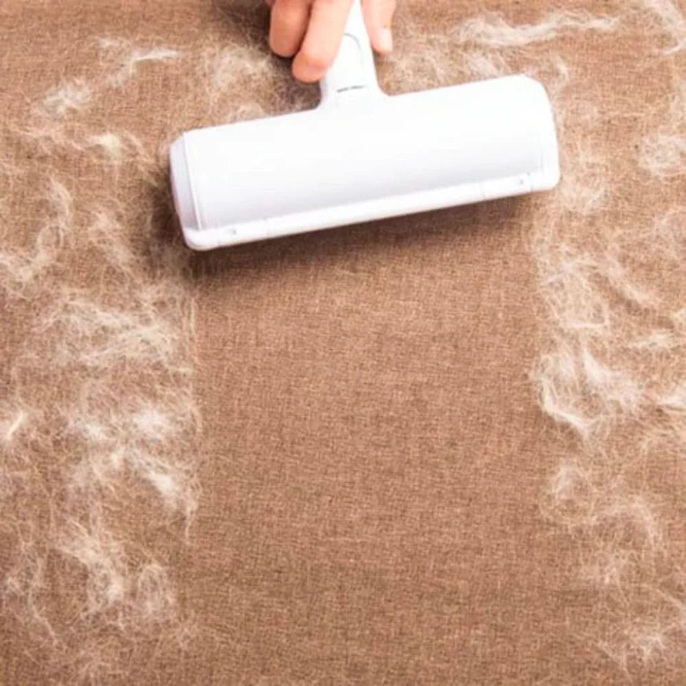 Person using a white roller to remove pet hair from a brown fabric surface