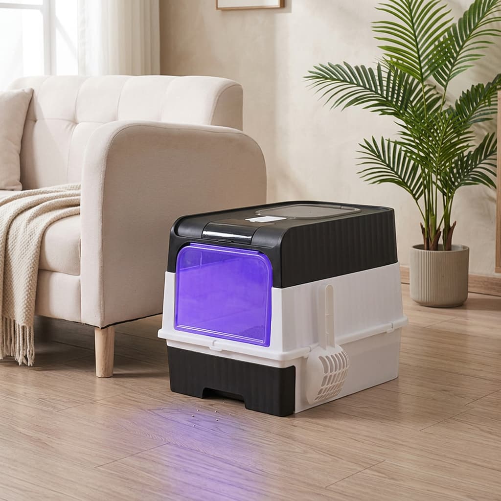 A pet litter box with a black and white plastic body and a glowing purple light inside, placed on a wooden floor next to a beige sofa and a potted plant.