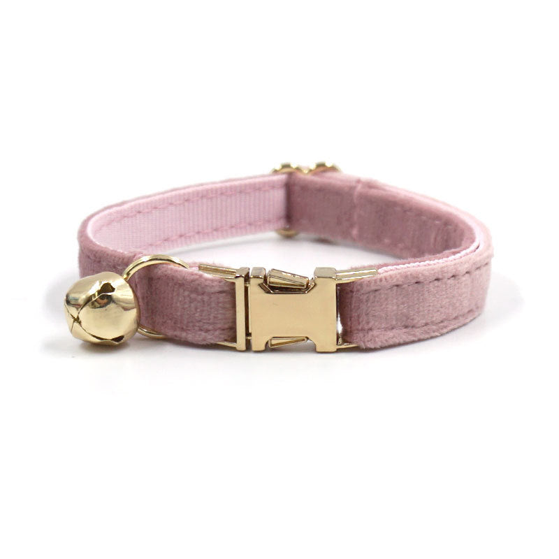 Pink cat collar with gold bell and buckle on a white background