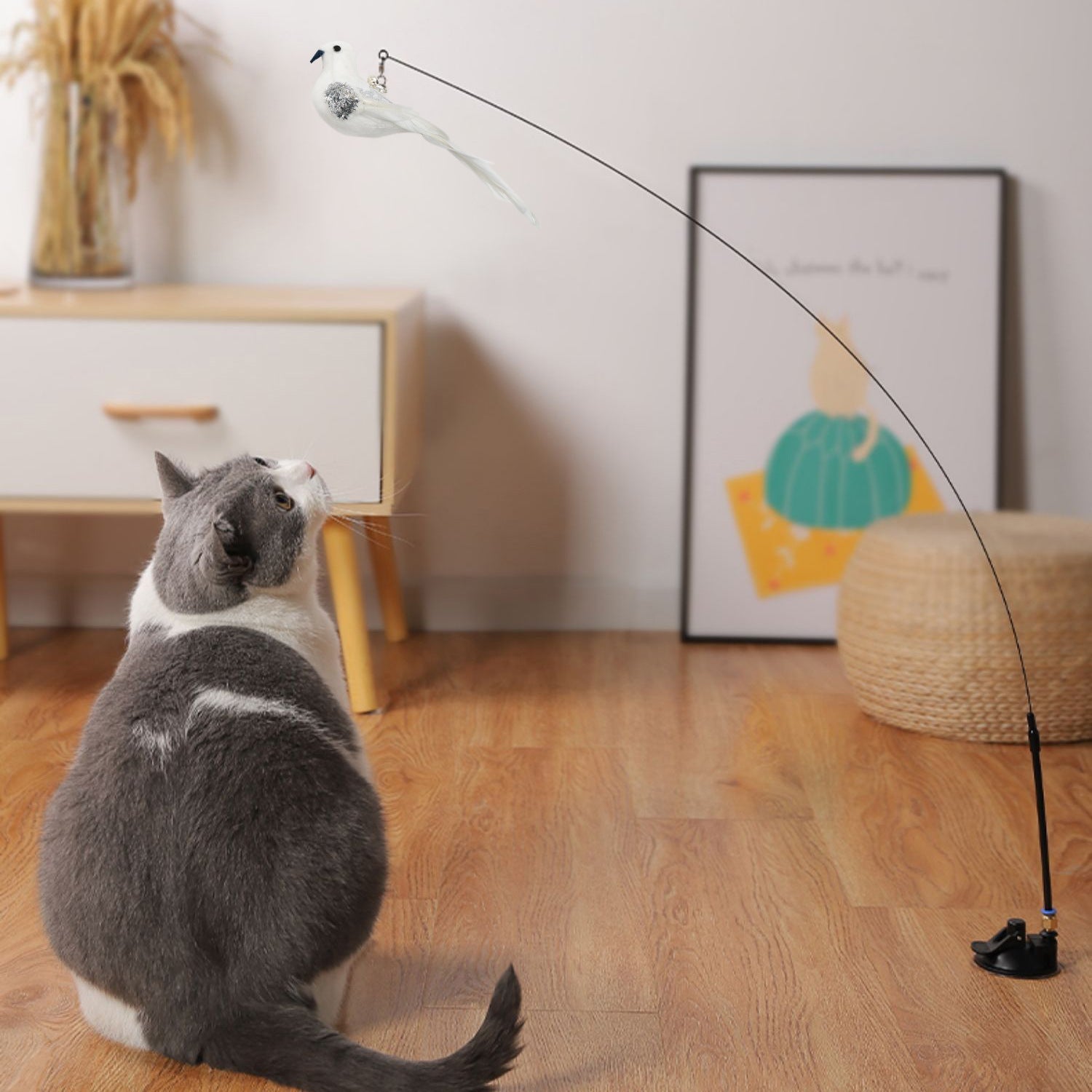 Cat playing with a laser pointer on a wooden floor.