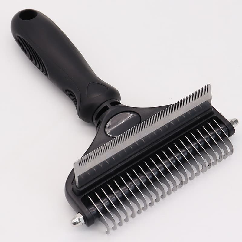 Pet grooming brush with black handle on a white background