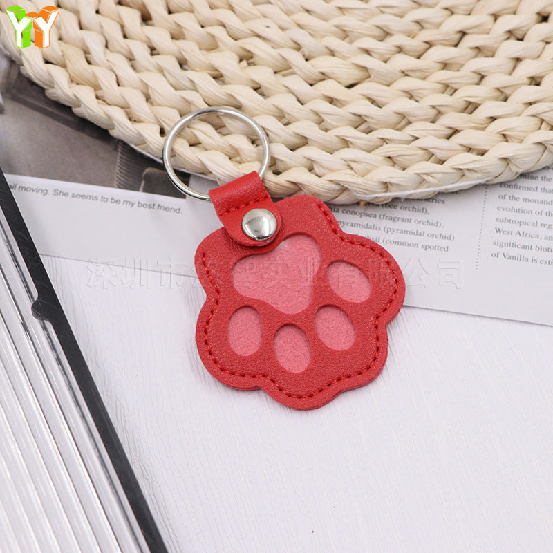 Red paw-shaped keychain on a textured surface