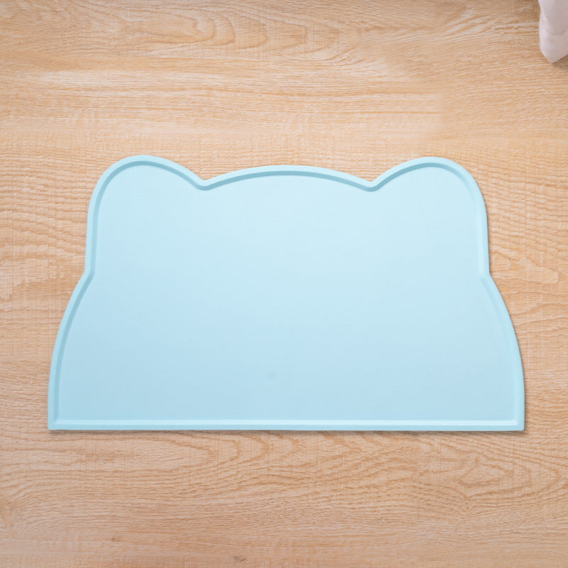 Light blue pet mat shaped like a cat's head on a wooden floor