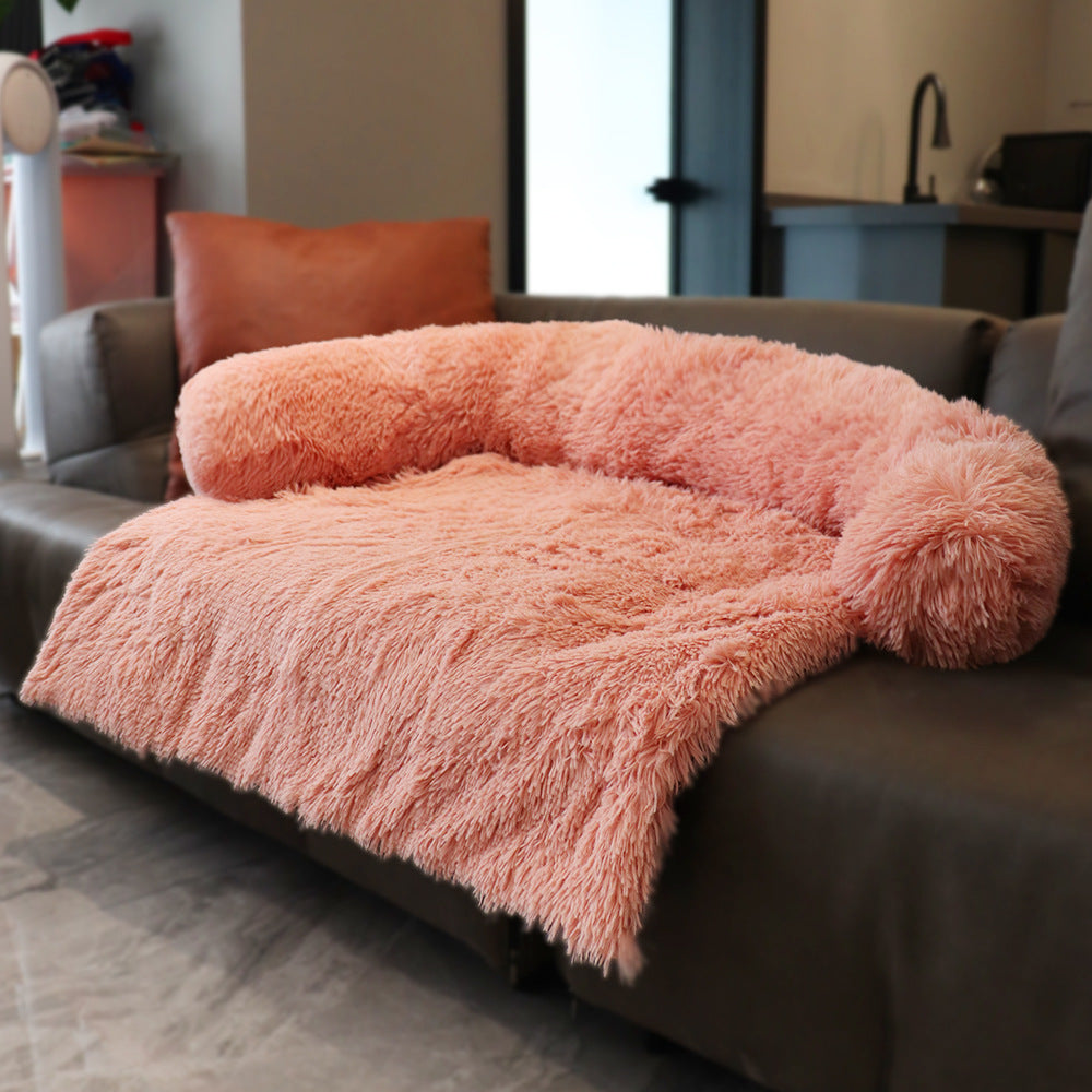 Pink fluffy blanket draped over a sofa in a living room setting.