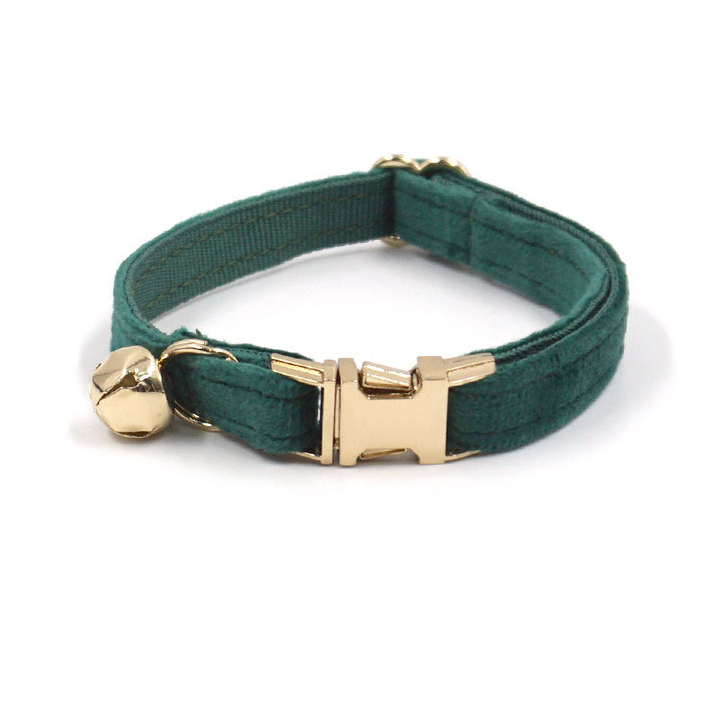 Green dog collar with gold buckle and bell on a white background