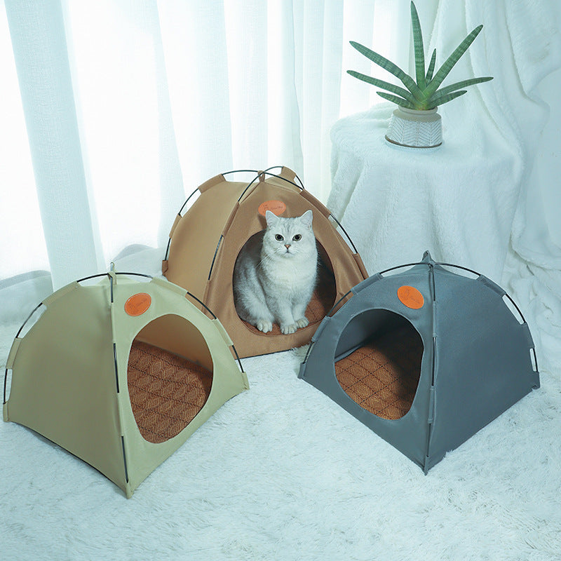 Three pet tents, one beige and one grey, with a cat peeking out from the beige tent on a white surface.