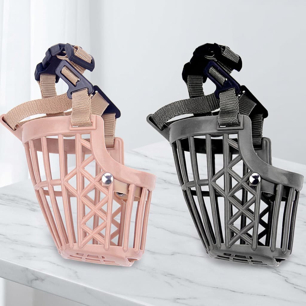 Two pet muzzle masks shown on a white marble surface against a light grey background. The left muzzle is light pink with beige straps and a navy plastic buckle.