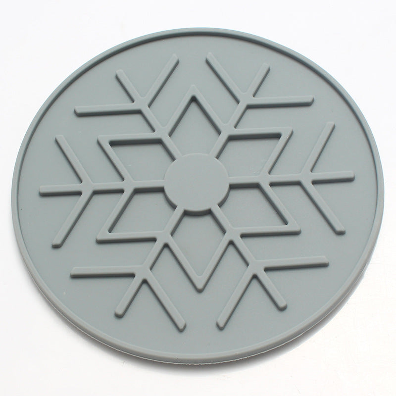 Grey circular object with a snowflake-like pattern on a white background