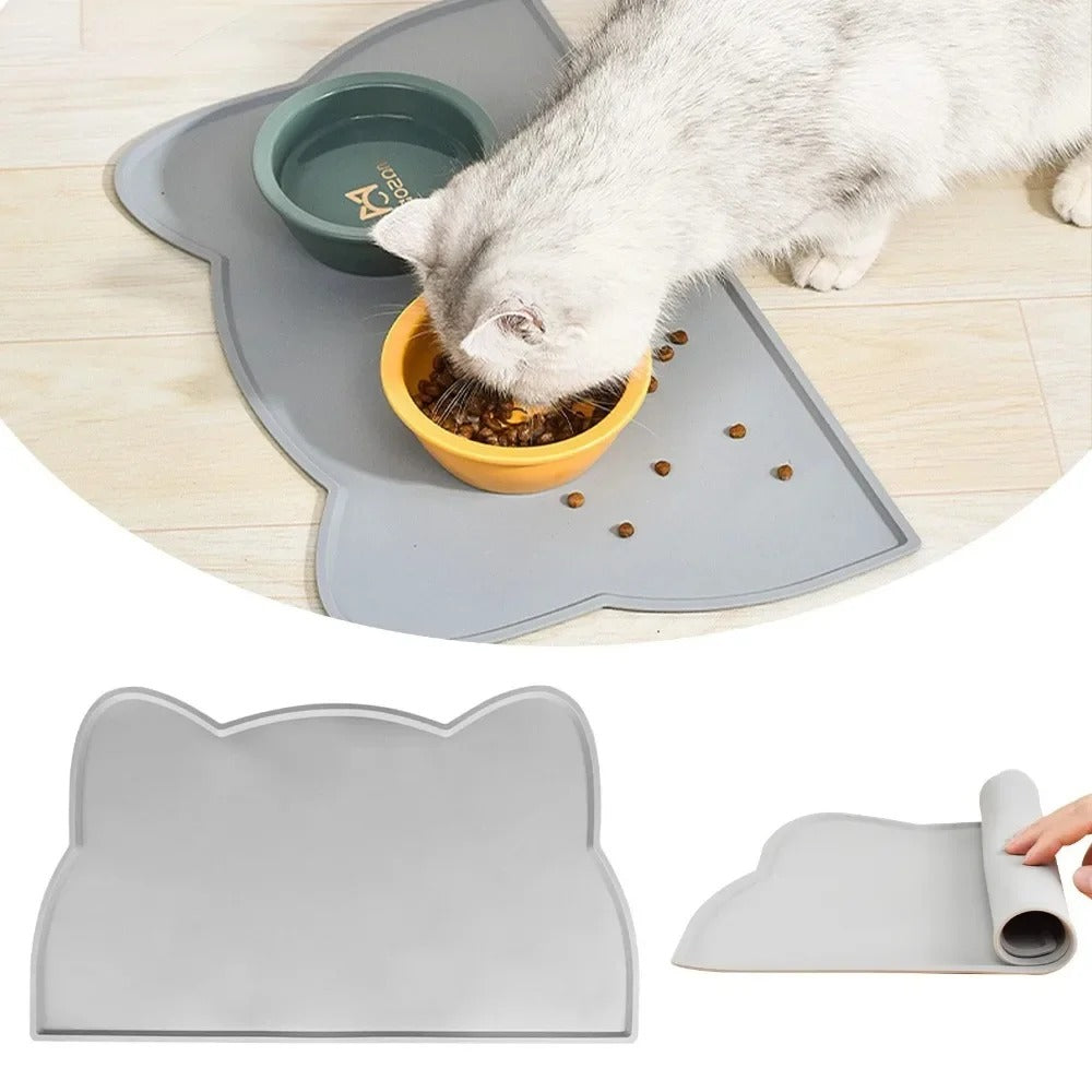 Cat eating from a bowl on a grey cat-shaped mat with additional mats shown below.