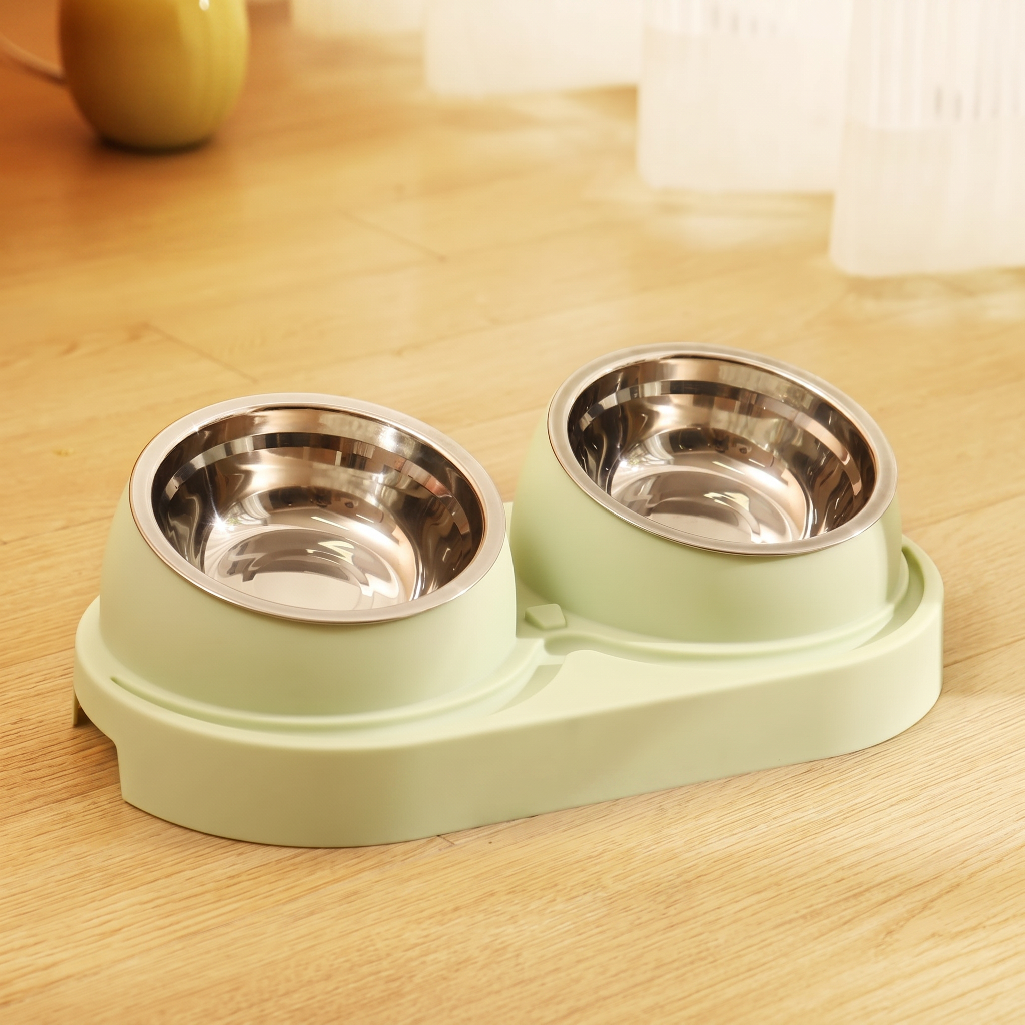 Pet food bowls with a green base on a wooden surface
