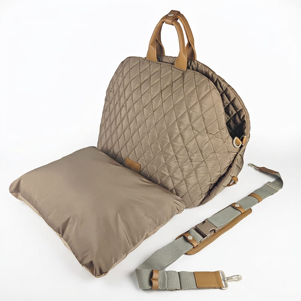 A beige handbag diaper bag seat pad with a matching padded insert, shown open on a white background with an adjustable shoulder strap laid beside it.