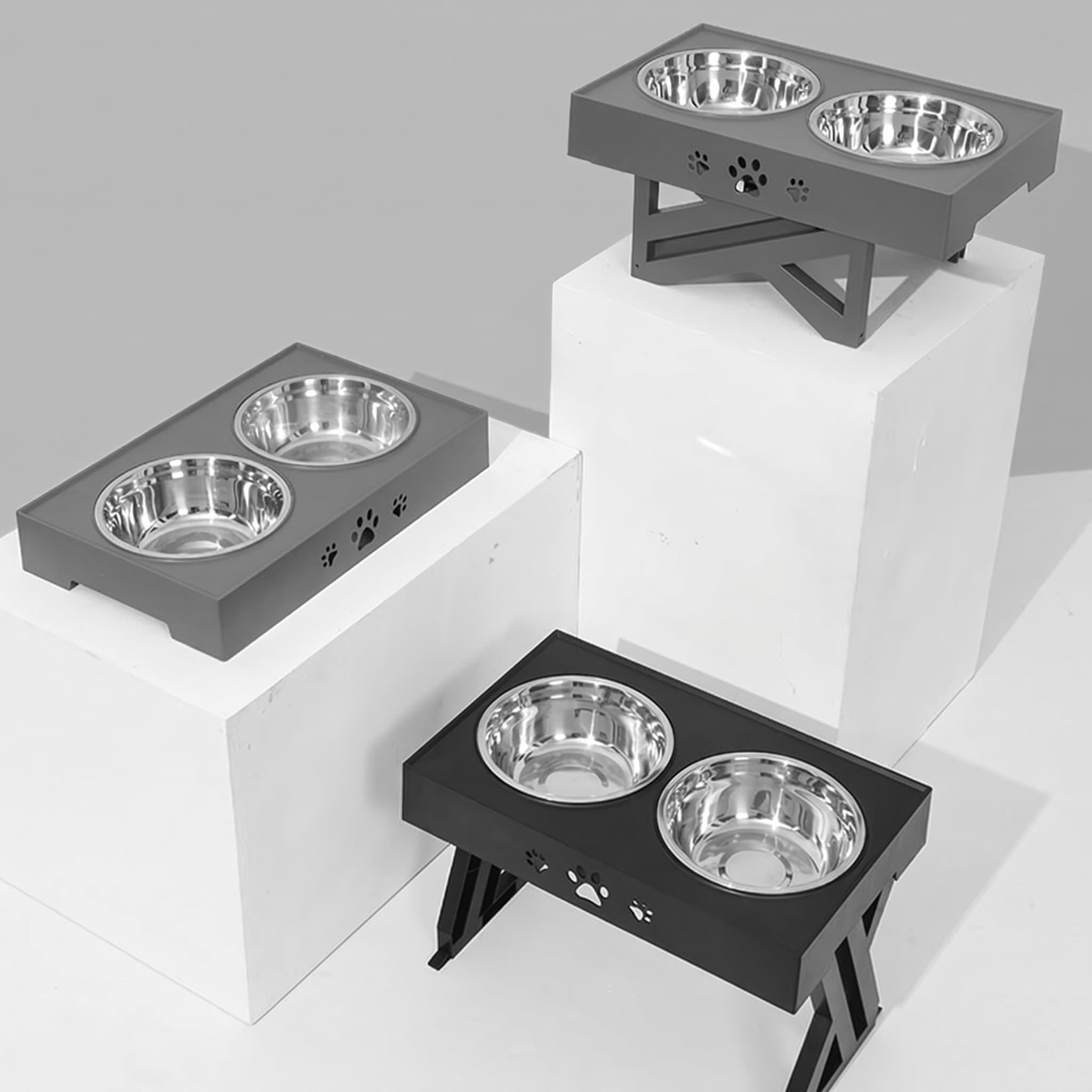 Three elevated pet feeding stations with stainless steel bowls on a white background