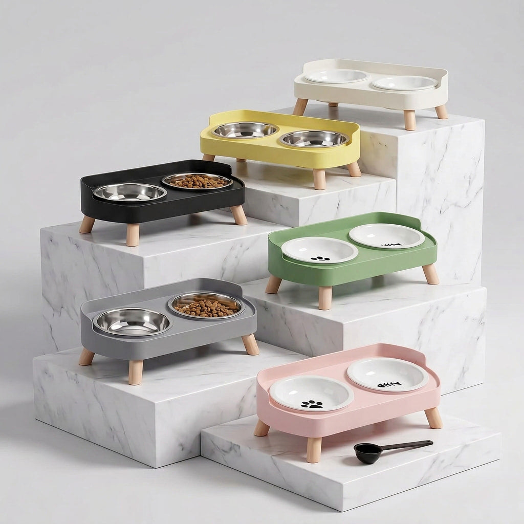 Six pet feeding stations in different colors (black, gray, yellow, green, pink, and cream) arranged on a white marble pedestal. Each station has a double bowl setup with stainless steel bowls and white bowls with paw print decals.